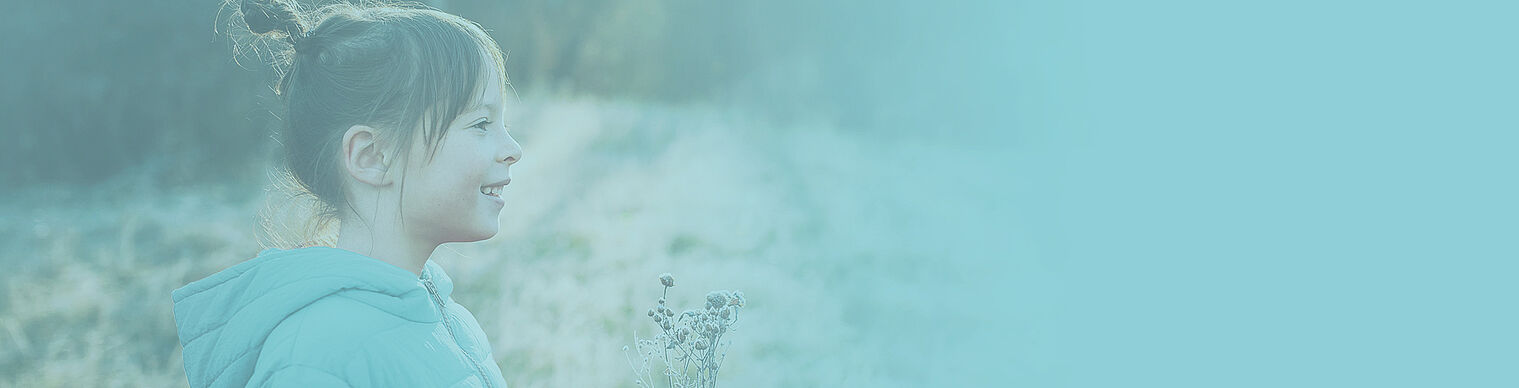 a small girl standing on grass